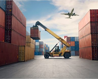 Crane lifting container, airplane flying overhead.
