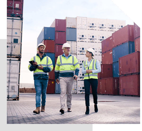 Workers walking in shipping container yard.